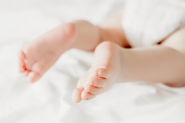 Pernas de bebê no fundo do espaço de cópia de roupa de cama branca os dedinhos do pé do bebê recém-nascido ucraniano