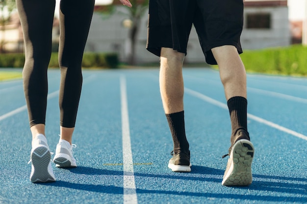 Pernas de corredores ao amanhecer Jogging no estádio Treinando atletas