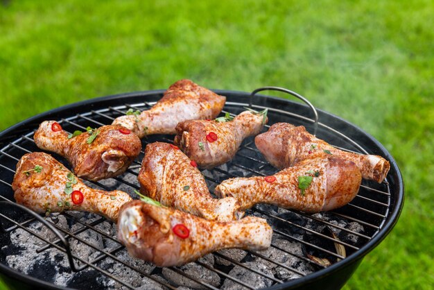 Pernas de coxinha de frango grelhando em carvão para churrasco de verão comida de piquenique no jardim do quintal