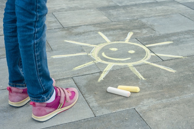 Pernas de criança com símbolo pintado do sol