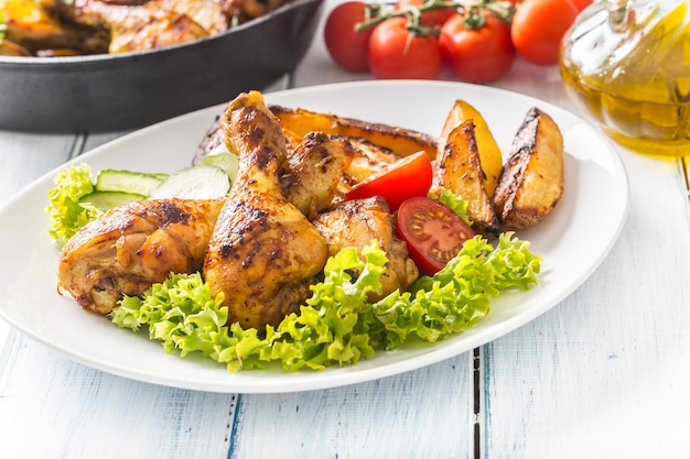 Pernas de frango assadas com salada de alface e tomate.