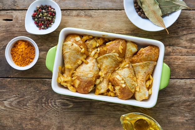 Pernas de frango cru com especiarias em forma de cerâmica