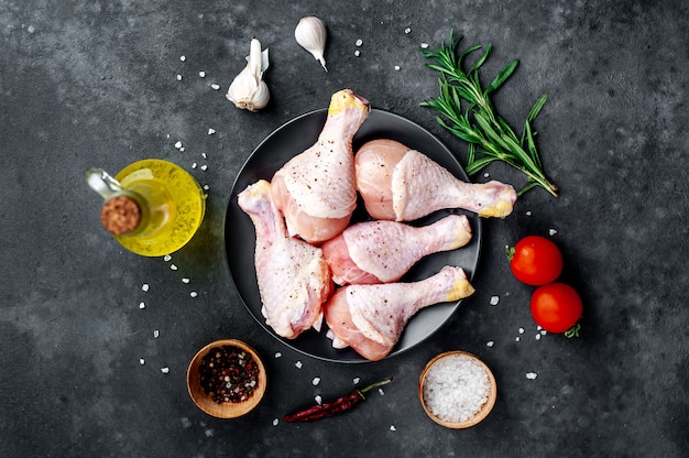 pernas de frango cru com especiarias em um fundo de pedra