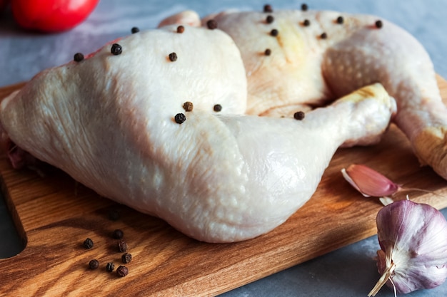 Pernas de frango cru com temperos na tábua