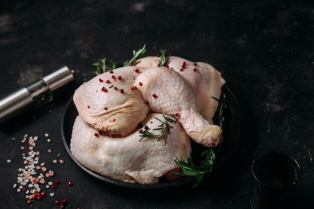 pernas de frango cru em um fundo escuro