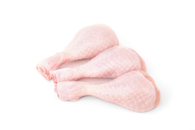 Pernas de frango cru isoladas no branco