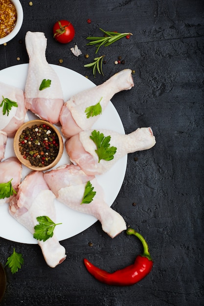 Foto pernas de frango cru no prato temperado