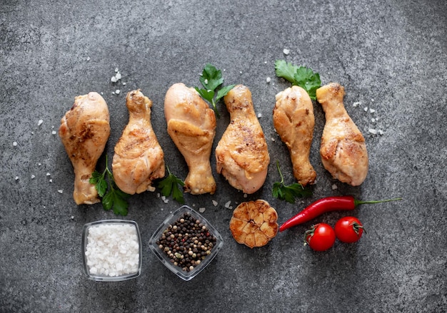 pernas de frango grelhado com especiarias em um fundo de pedra