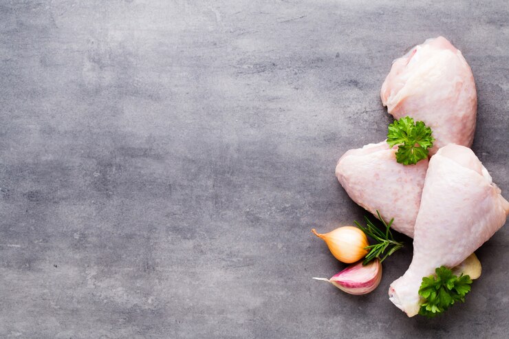 Foto pernas de marinada de frango, legumes frescos em um cinza