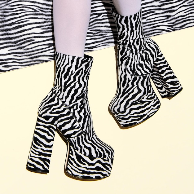 Pernas de moda em botas de zebra de festa de calcanhar em fundo mínimo