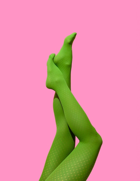 Pernas de mulher em meia-calça verde isoladas em um fundo rosa