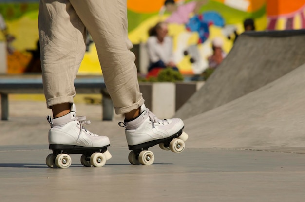 pernas de mulher em patins artísticos andando em skatepark