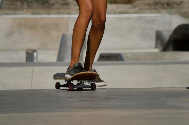 pernas de mulher em um skate skateboard