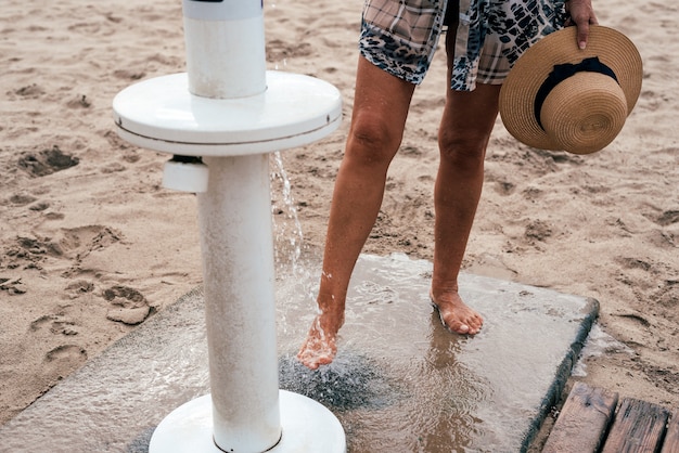 Foto pernas de mulher no chuveiro na praia