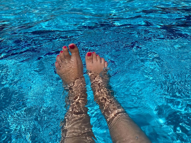 Pernas de mulher sobre a piscina