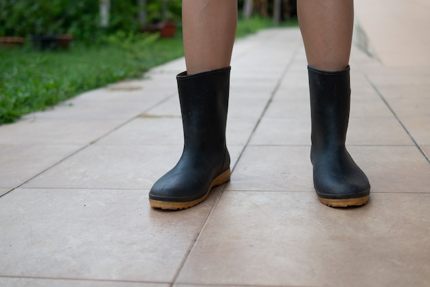 Foto pernas de mulher usam botas agrícolas para agricultura ou jardinagem conceito de estilo de vida