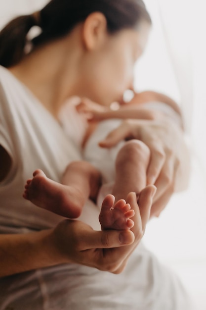 Pernas de um bebê recém-nascido nas mãos dos pais