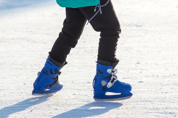 Pernas de um patinador na patinação no gelo na pista de gelo de rua. esporte de inverno. passatempos e recreação ativa nos esportes.
