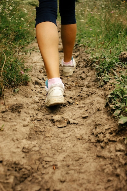 Pernas elegantes de mulher em tênis andando no solo exercício ao ar livre