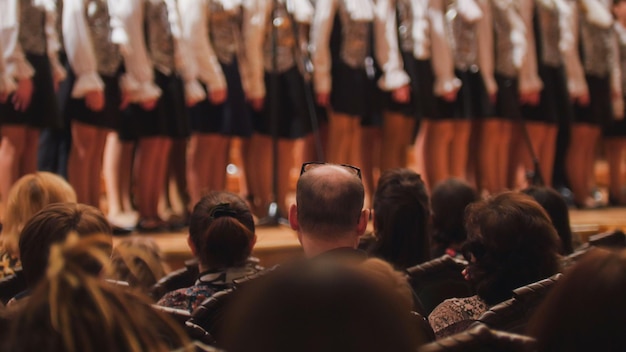 Pernas em meia-calça de coro de meninas ensaiando canção acadêmica