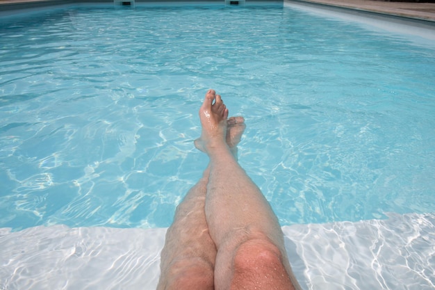 Pernas em uma bela piscina em um dia de verão