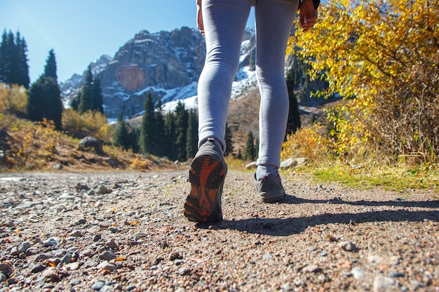 Pernas femininas atléticas em sapatos profissionais. Treinamento nas montanhas.