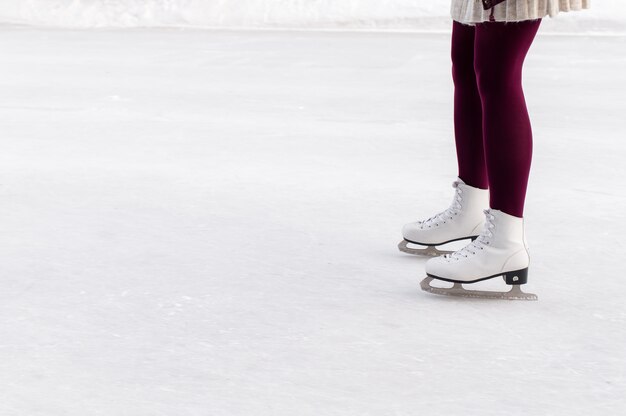 Pernas femininas de patins em uma pista de patinação