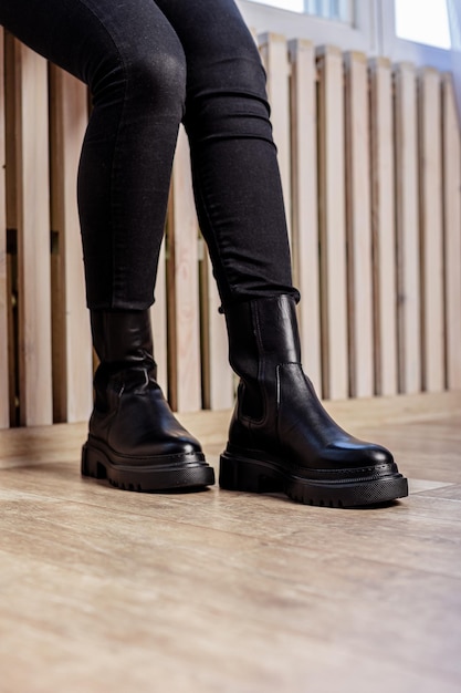 Pernas femininas em botas de couro preto. Nova coleção de botas de inverno para senhora