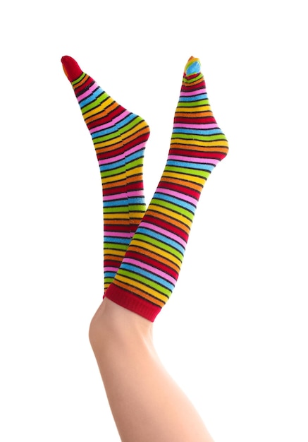 Pernas femininas em meias listradas coloridas isoladas em branco
