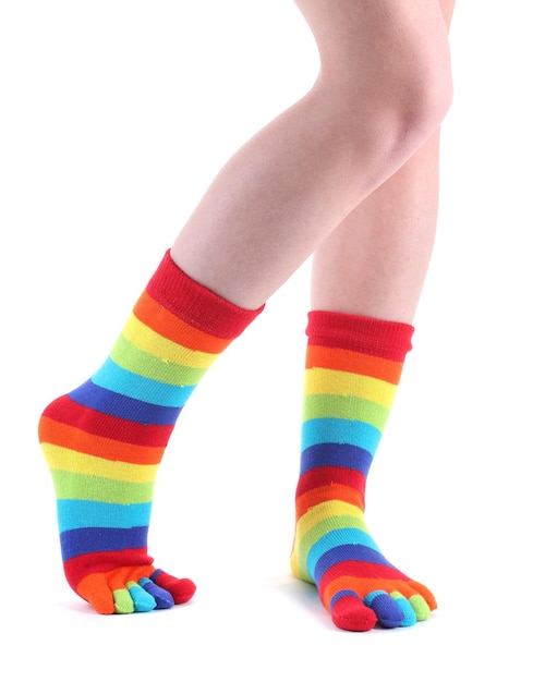 Pernas femininas em meias listradas coloridas isoladas em branco