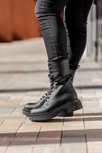 Pernas femininas esbeltas close-up em botas de couro genuíno. Nova coleção de sapatos femininos de primavera