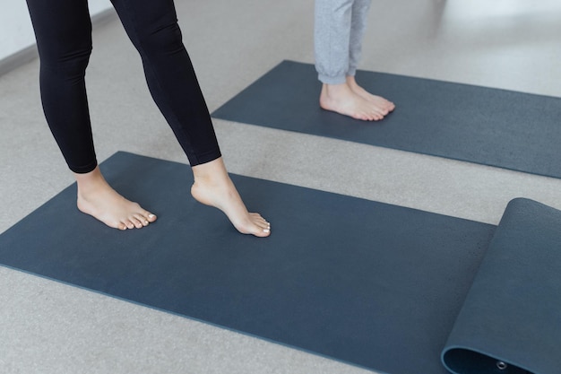 Pernas femininas finas em um tapete de ioga Estilo de vida saudável e treinamento do corpo e do espírito Interior fechado