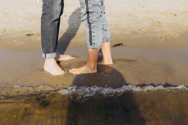 Pernas masculinas e femininas na praia