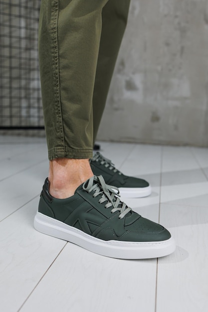 Pernas masculinas em calças e tênis casuais verdes Sapatos da moda masculinos