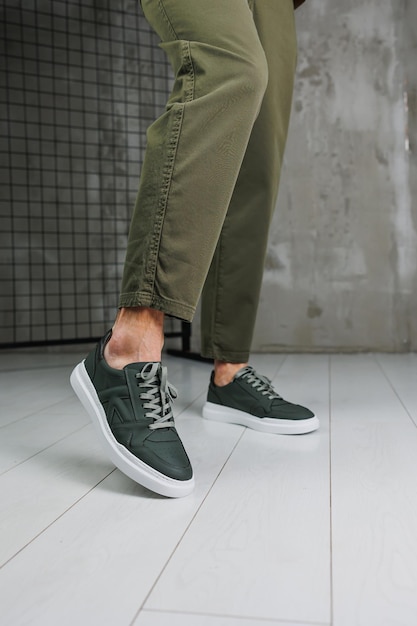 Pernas masculinas em calças e tênis casuais verdes Sapatos da moda masculinos