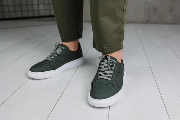 Pernas masculinas em calças e tênis casuais verdes Sapatos da moda masculinos