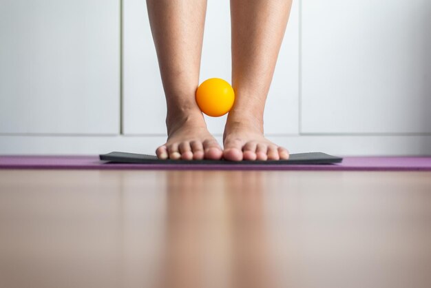 Foto pernas massagem acupressão com bola de borracha para aliviar a dor em casa