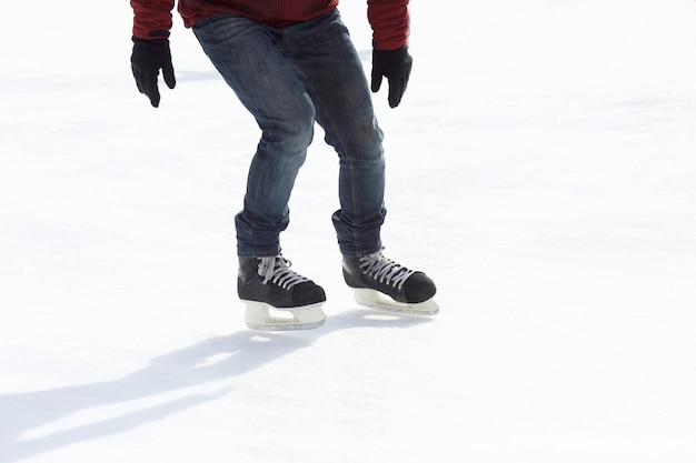 Pernas montam um cara patinando na pista de gelo