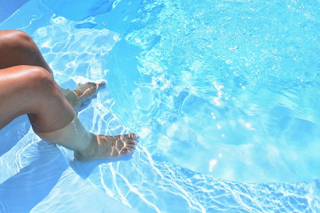 Pernas na piscina com água limpa Fundo de verão para viagens e férias