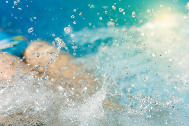 Pernas na piscina espirrando água