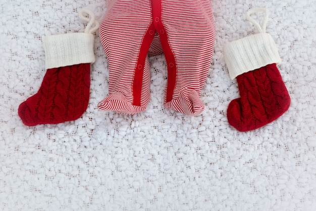 Pernas recém-nascidas com meias vermelhas de Natal em um cobertor branco