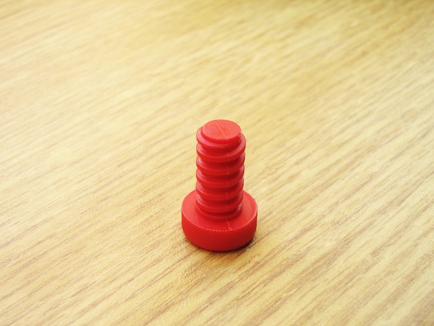 Perno infantil rojo sobre la mesa de madera