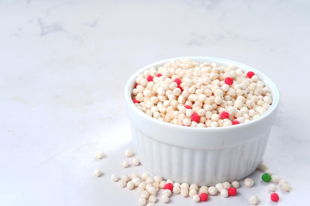 pérolas de tapioca em uma tigela de madeira no fundo branco