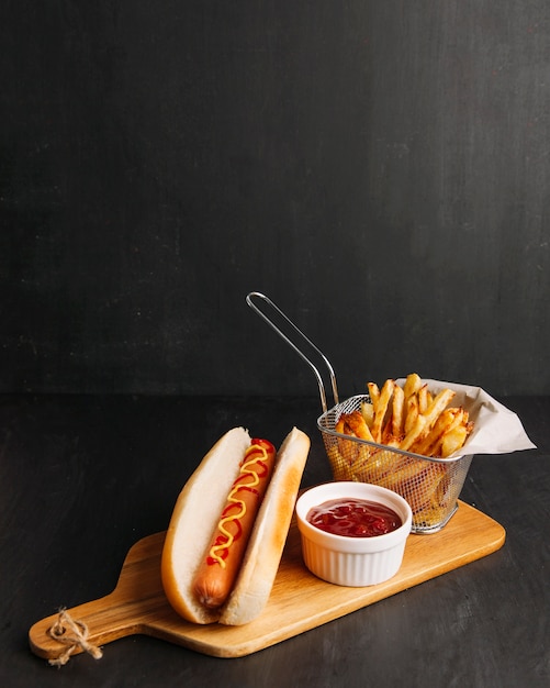 Perrito caliente y patatas fritas en tabla de madera