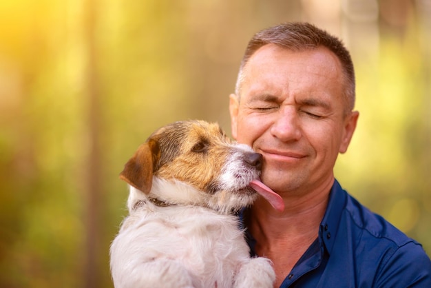 Perrito lame la cara de un hombre