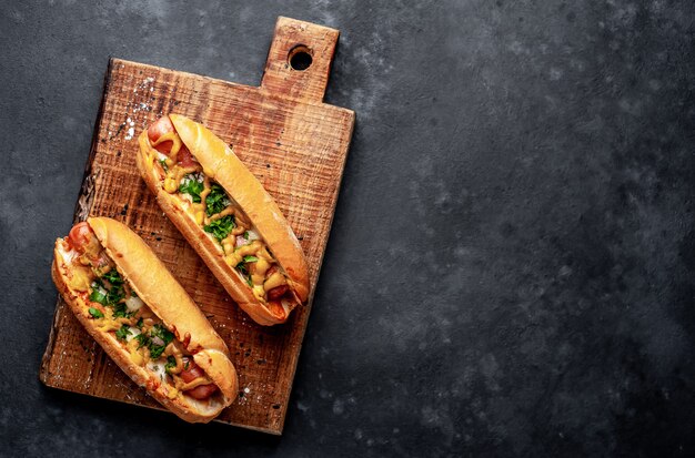 Perritos calientes franceses al horno con queso y mostaza sobre un fondo de piedra