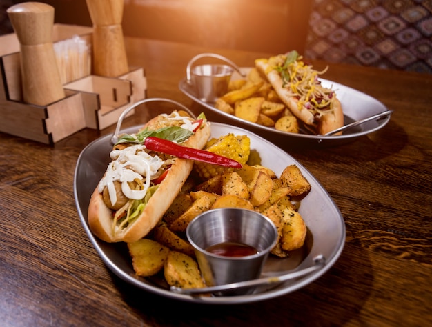 Perritos calientes y papas fritas en un plato. Comida de comida rápida. Restaurante.