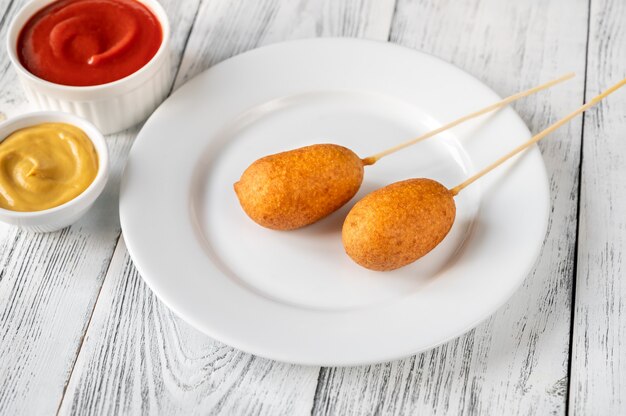 Perritos de maíz con salsas en un plato blanco