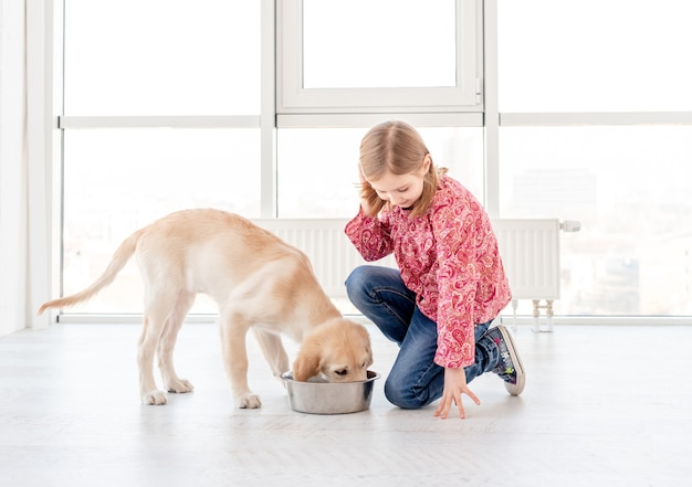 Perro de alimentación linda chica