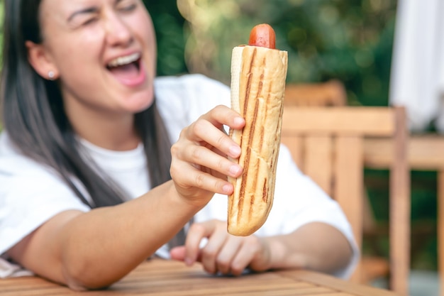 Foto perro caliente en manos de un primer plano de mujer